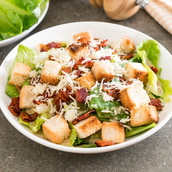 Caesar salad with crisp romaine lettuce, crunchy croutons, bacon bits, and shredded Parmesan cheese.
